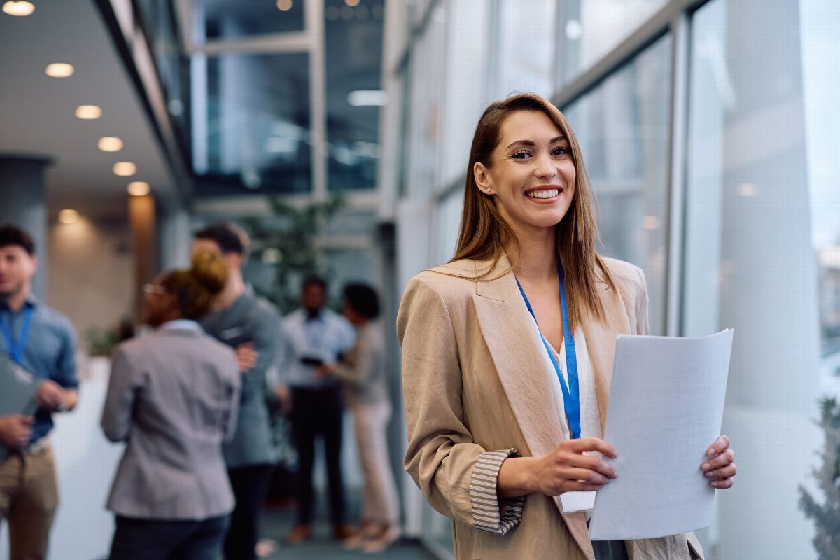 A smiling trainer holding her notes at a professional event